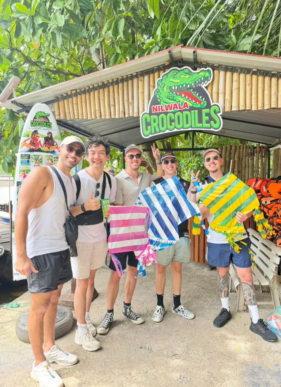 Guests posing beneath the Nilwala Crocodiles sign after their safari